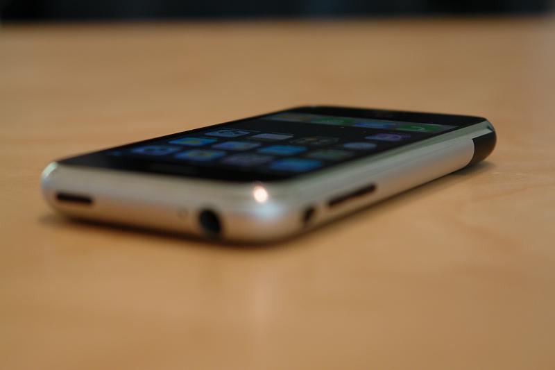 photo of older iphone, lying on its side on a table or desk