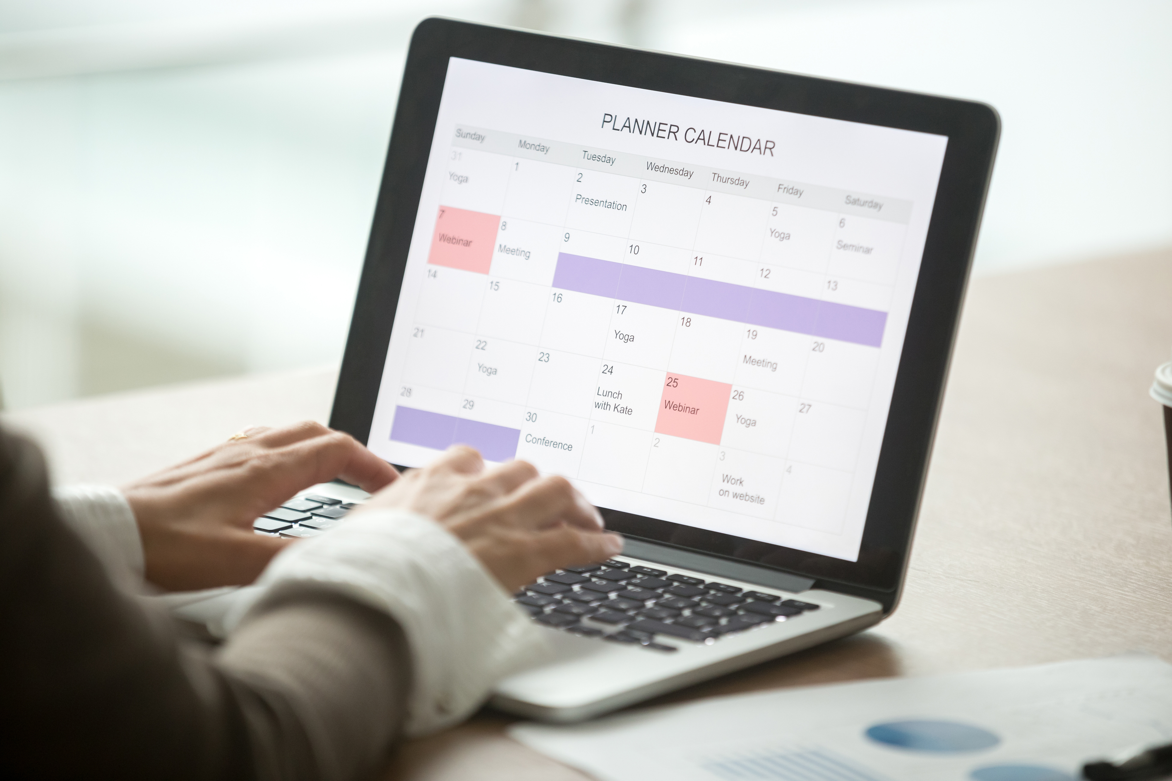 Businesswoman planning day using digital calendar on laptop