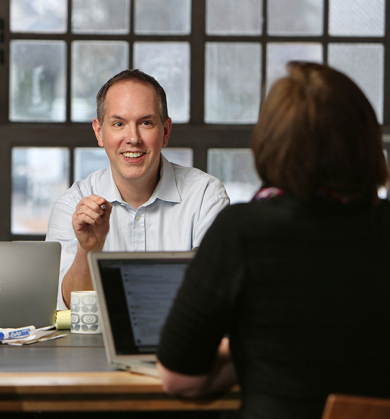 Dan talking to others during a meeting at a conference table