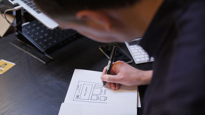 Dan sketching a webpage layout on paper