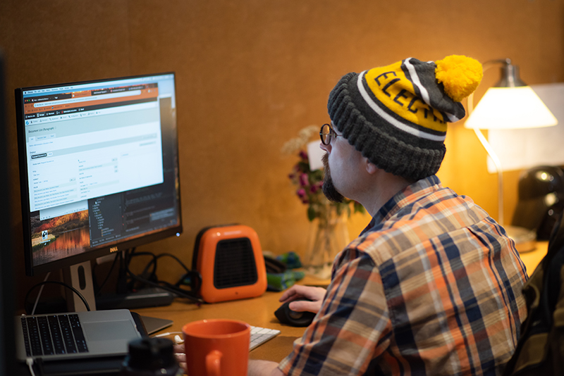 web developer sitting at desk coding on computer