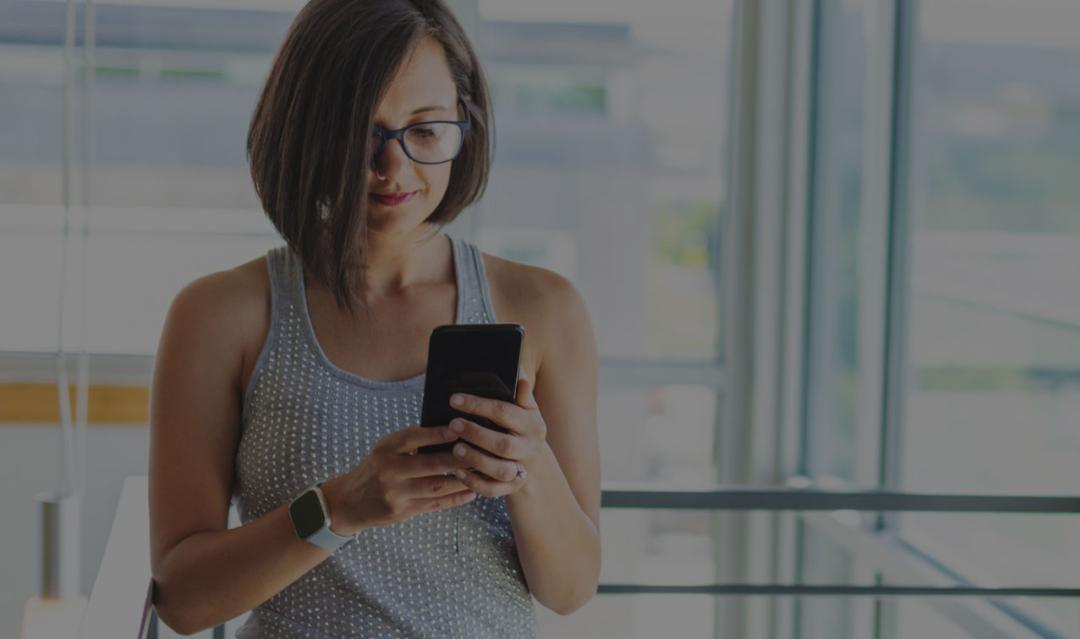 business woman at the office searching the web on her mobile phone