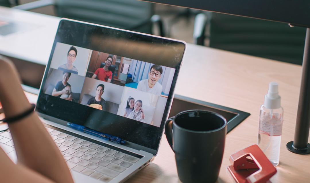 woman sitting at a desk video conferencing with others