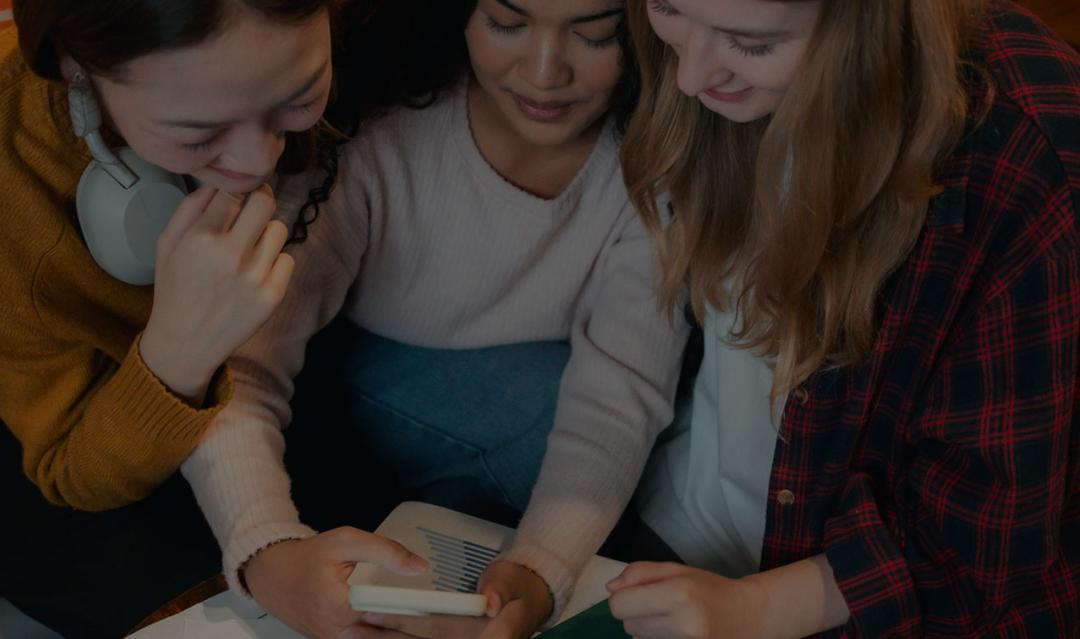 Group of friends gathered around a smartphone, using an app