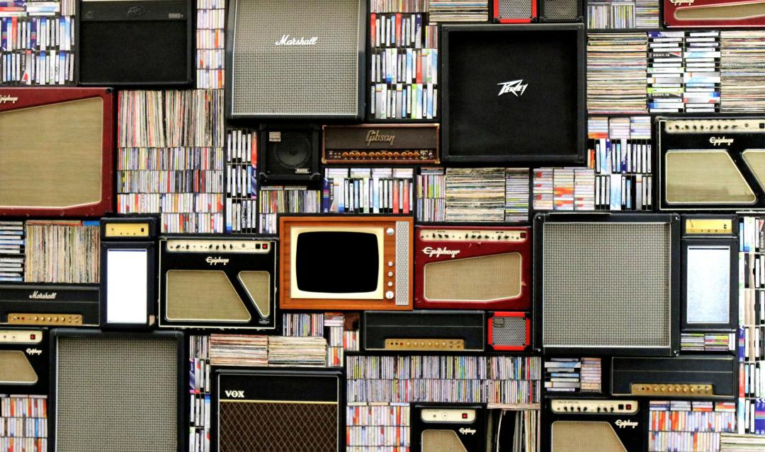 Bookshelf with vintage books, speakers and tvs