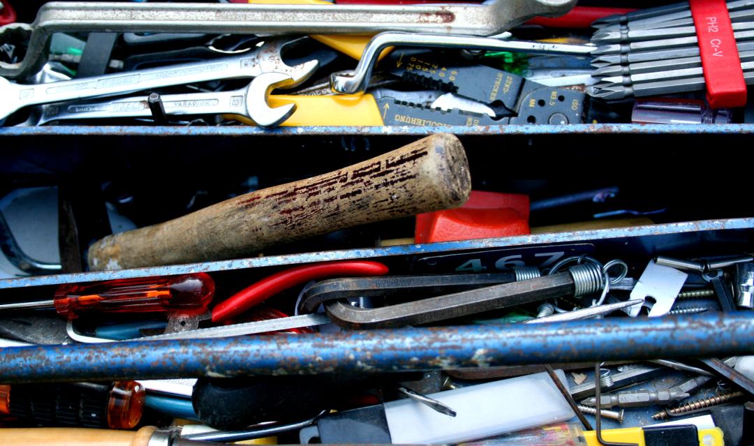 Toolbox top shelf filled with used tools.