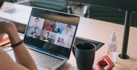 woman sitting at a desk video conferencing with others