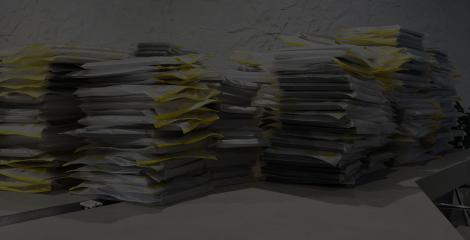 piles of papers stacked across the top of an office desk