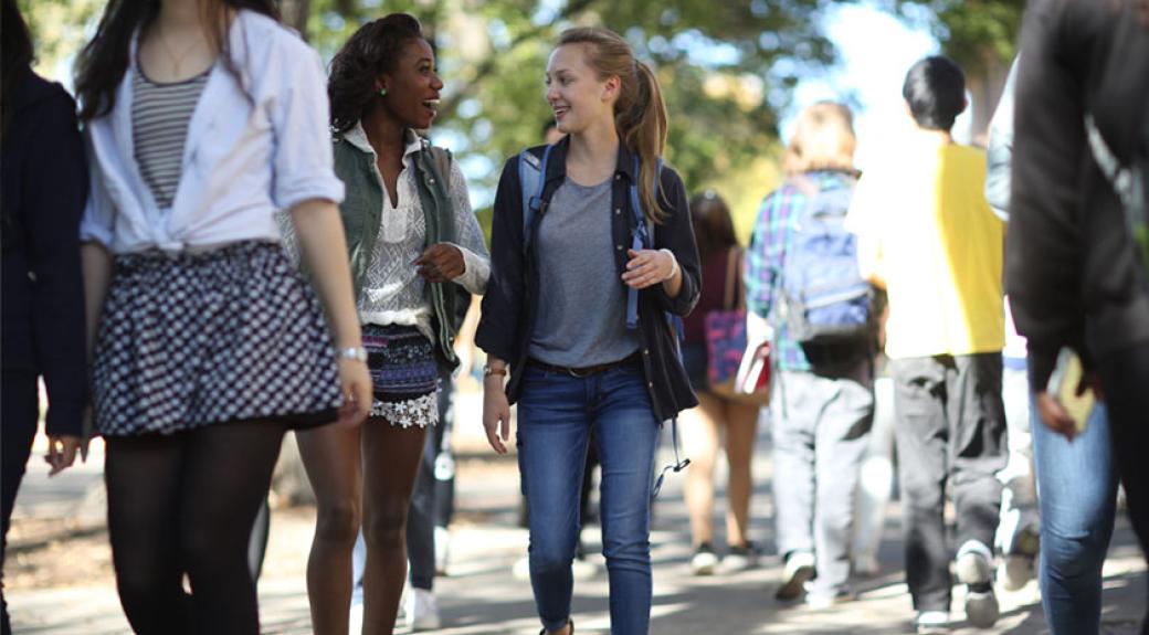 Two young women talking and walking on Morris campus