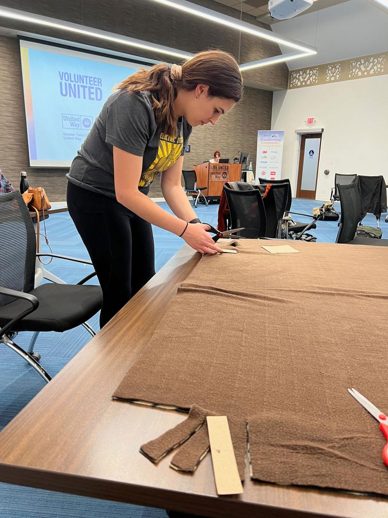 Olivia cutting fabric at volunteer event