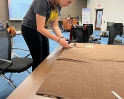 Olivia cutting fabric at volunteer event