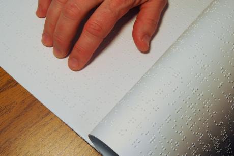 photo of persons hand using braille