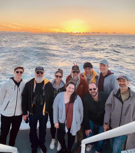 team members posing on a sunset cruise off the coast of San Diego