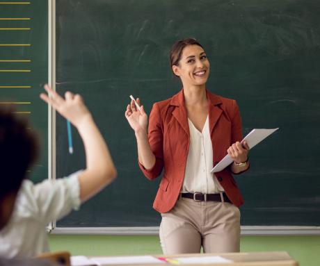 Women teacher standing in front of a classroom answering questions