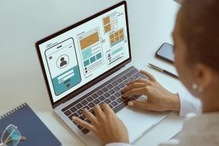 designer working on a page layout on a laptop