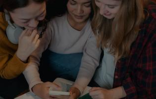 Group of friends gathered around a smartphone, using an app