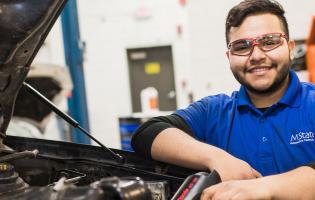 Automotive repair student in a garage with vehicle