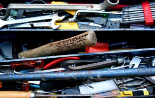 Toolbox top shelf filled with used tools.