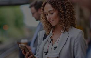 woman reading on phone while waiting for a train