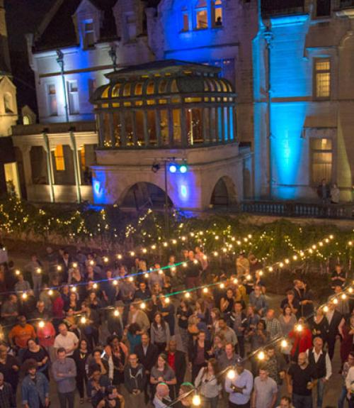 large group socializing in the museum courtyard at night